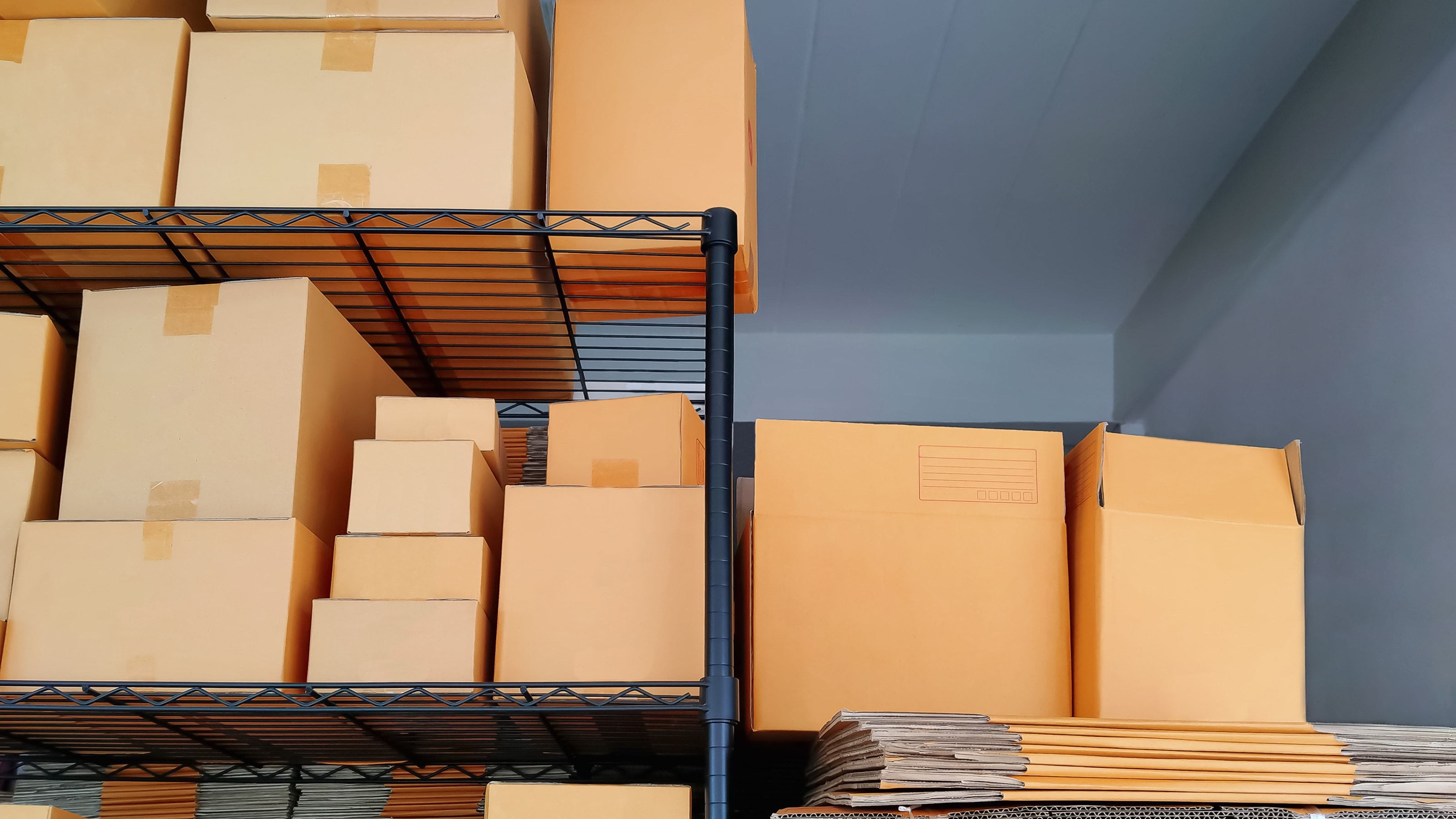 Cajas de cartón de varios tamaños en estantería — elegir tamaño correcto