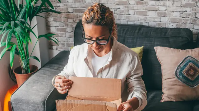 Persona abriendo paquete delivery — momento experiencia unboxing